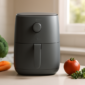Energiezuinige airfryer op een modern keukenblad met verse groenten ernaast