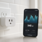 Slimme stekker in stopcontact met energieverbruik-app op smartphone in keuken